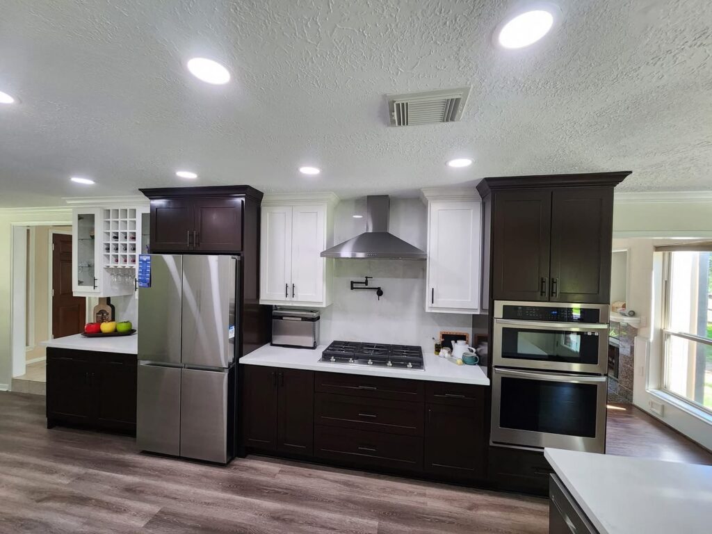 Modern white kitchen with large center island and stainless steel fridge