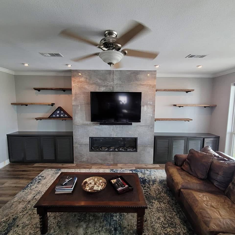 Living room with built-in shelves, fireplace, and mounted TV
