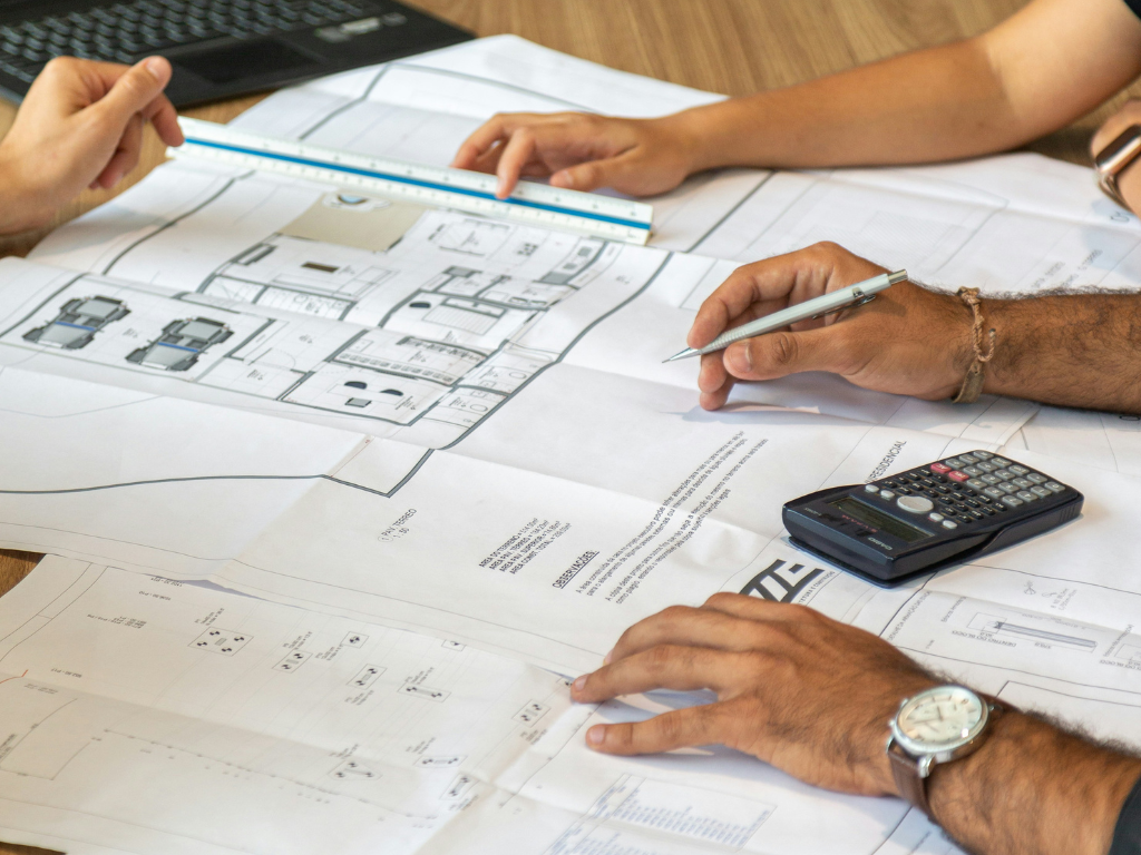 Two people reviewing architectural blueprints and floor plans